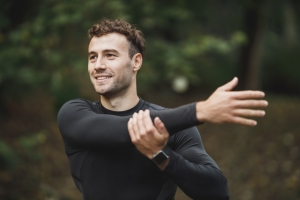 Athlete stretching his arm outdoors