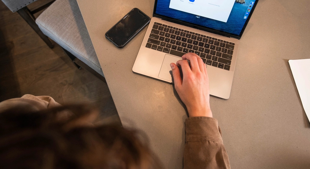 Hands typing on a laptop while shopping online