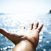 Open hand against sparkling water, a calm moment