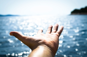 Open hand against sparkling water, a calm moment