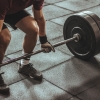 Lifter gripping a loaded barbell for a deadlift