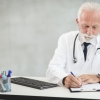 Senior doctor writing notes after a low testosterone consultation