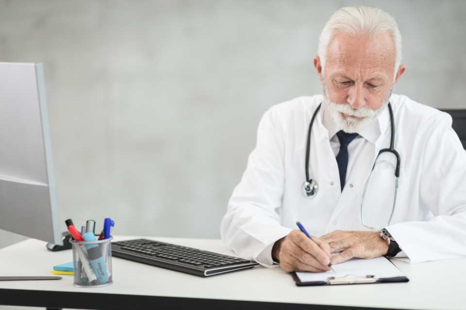 Doctor writing a prescription at his desk