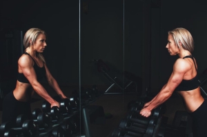 Two women training with dumbbells in a gym