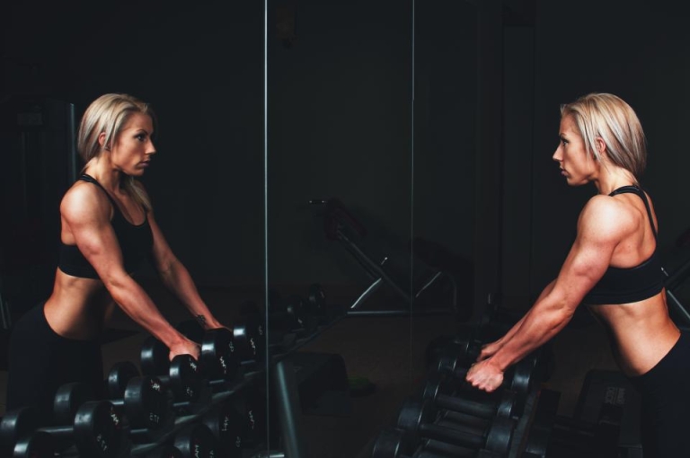 Two women training with dumbbells in a gym