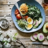 Healthy bowl with greens, egg and avocado
