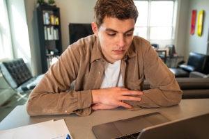 Young man sitting at a table, deep in thought