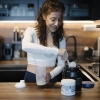 Woman mixing a protein shake in her kitchen