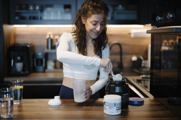 Woman mixing a protein shake in her kitchen