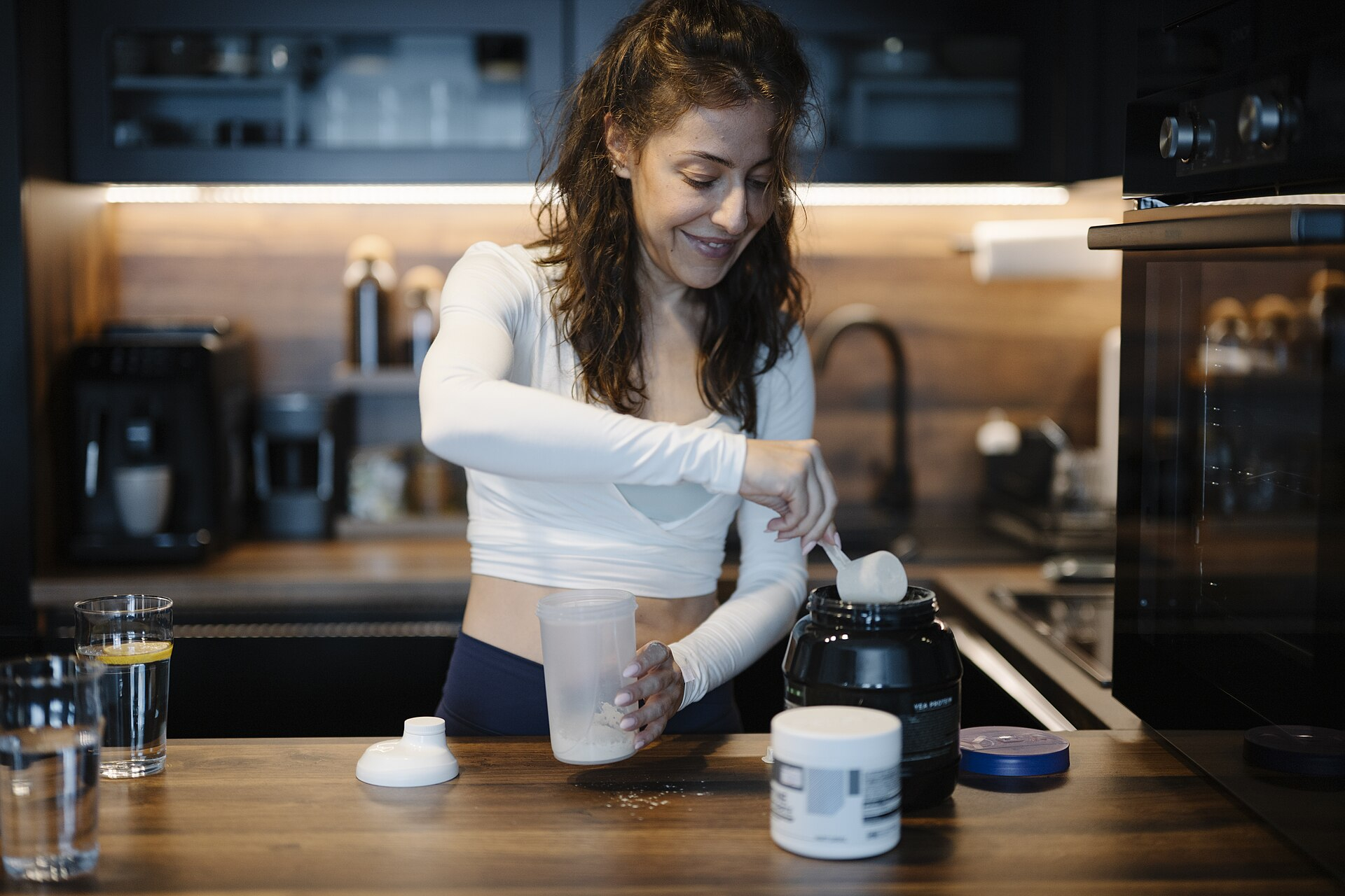 Woman mixing a protein shake in her kitchen
