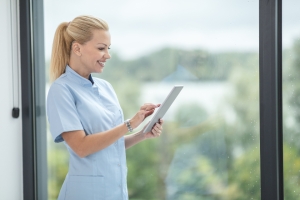 Nurse reviewing information on a tablet in a clinic