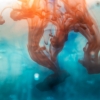 Coloured ink swirling through clear water