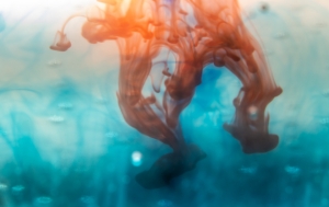 Coloured ink swirling through clear water