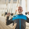 Older man lifting dumbbells outdoors