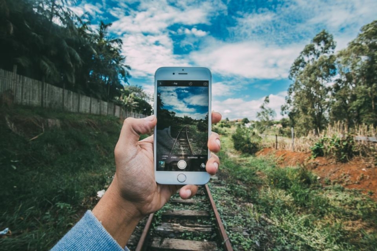 Hand holding a phone outdoors