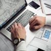 Person planning at a laptop with notes