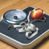 Bathroom scale with a measuring tape and apple