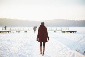 Person walking along a snowy lakeshore