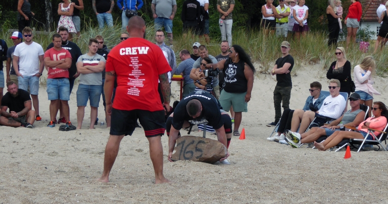 Strongman competitor lifting at an outdoor event