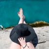 Person in a sun hat relaxing by the water