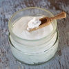 Jar of supplement powder with a wooden scoop