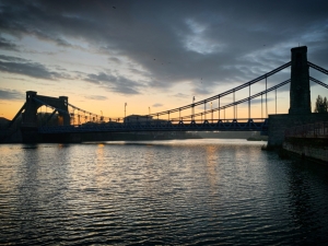 Suspension bridge over water at sunset