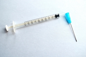 Syringe with needle on a white surface