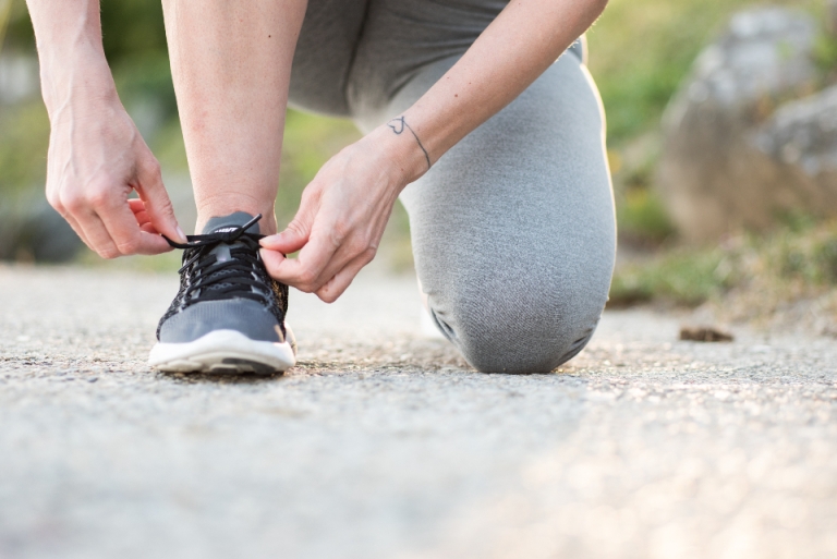 Runner tying a shoe before a morning run