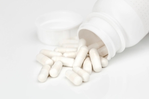 White capsules spilling from a bottle